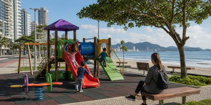 Niños jugando en un parque infantil junto a la playa en Itapema