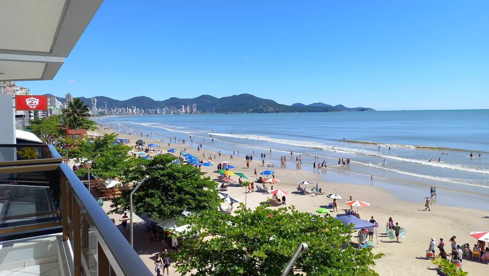Meia Praia con bañistas, sombrillas y la orla de Itapema