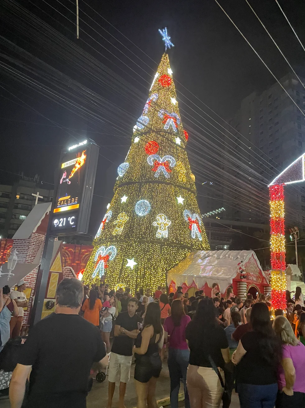 Árbol de Navidad iluminado con personas reunidas en Itapema